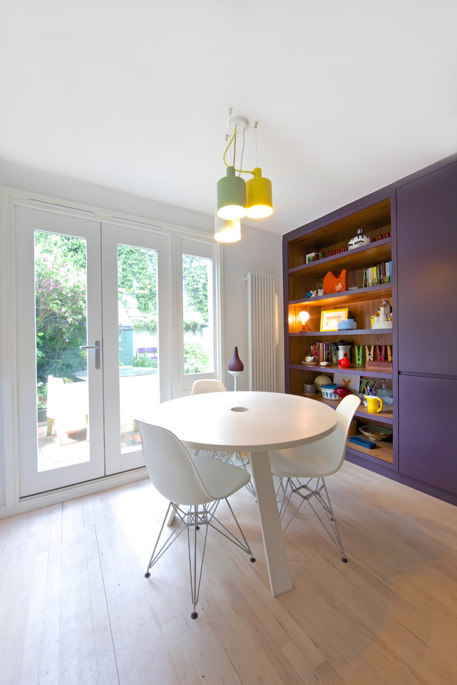 Moderne Wohnküche mit flächenbündigen Schrankfronten, weißen Schränken und hellem Holzboden in London