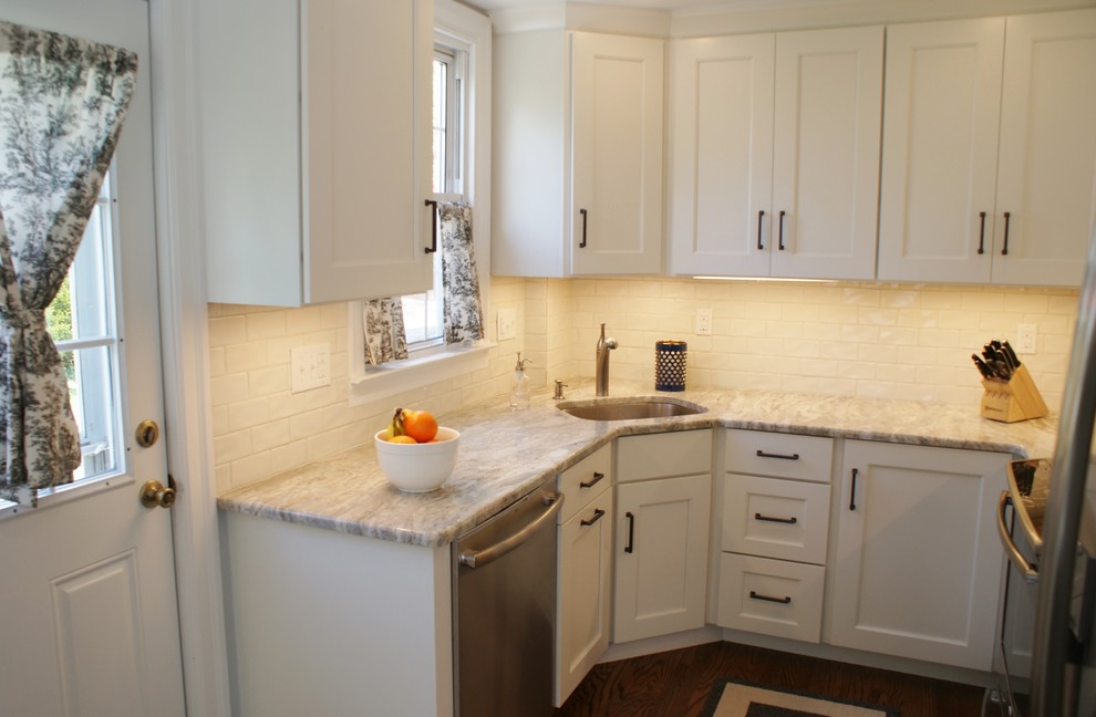 Kitchen - small transitional u-shaped dark wood floor and brown floor kitchen idea in Philadelphia with an undermount sink, shaker cabinets, white cabinets, marble countertops, white backsplash, subway tile backsplash and stainless steel appliances