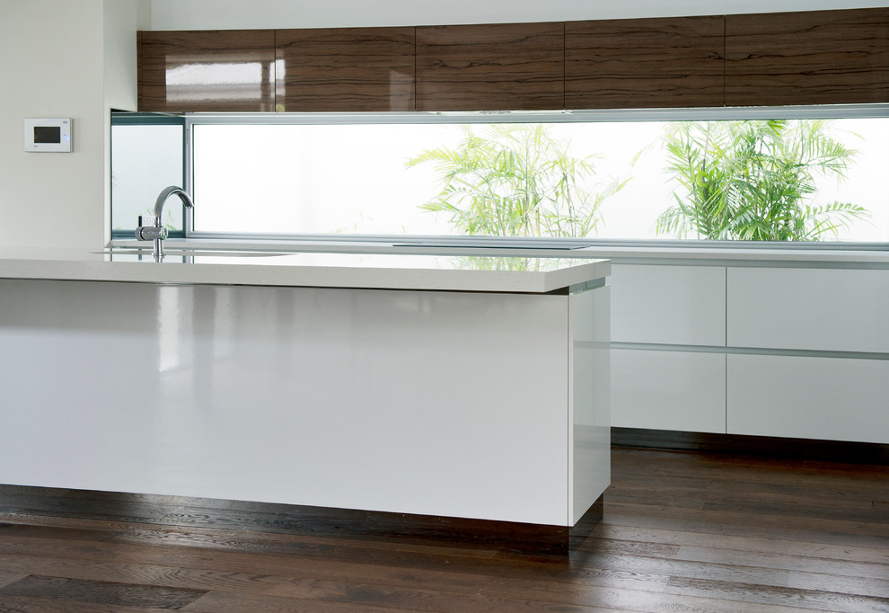 Contemporary kitchen in Perth with a submerged sink, flat-panel cabinets, white cabinets, composite countertops, window splashback, dark hardwood flooring, an island and brown floors.