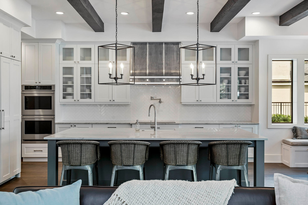 Large transitional l-shaped medium tone wood floor and brown floor open concept kitchen photo in Orlando with a farmhouse sink, glass-front cabinets, white cabinets, marble countertops, white backsplash, stainless steel appliances, an island, mosaic tile backsplash and white countertops