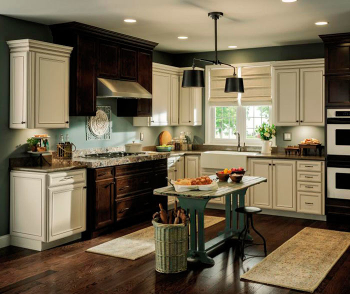 Inspiration for a mid-sized transitional l-shaped dark wood floor eat-in kitchen remodel in Other with a farmhouse sink, shaker cabinets, white cabinets, granite countertops, gray backsplash, subway tile backsplash and stainless steel appliances