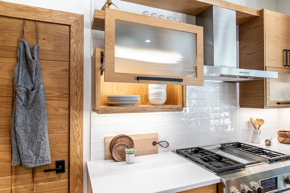 Immagine di una cucina nordica con ante in legno chiaro, paraspruzzi bianco, elettrodomestici in acciaio inossidabile, parquet scuro e top nero