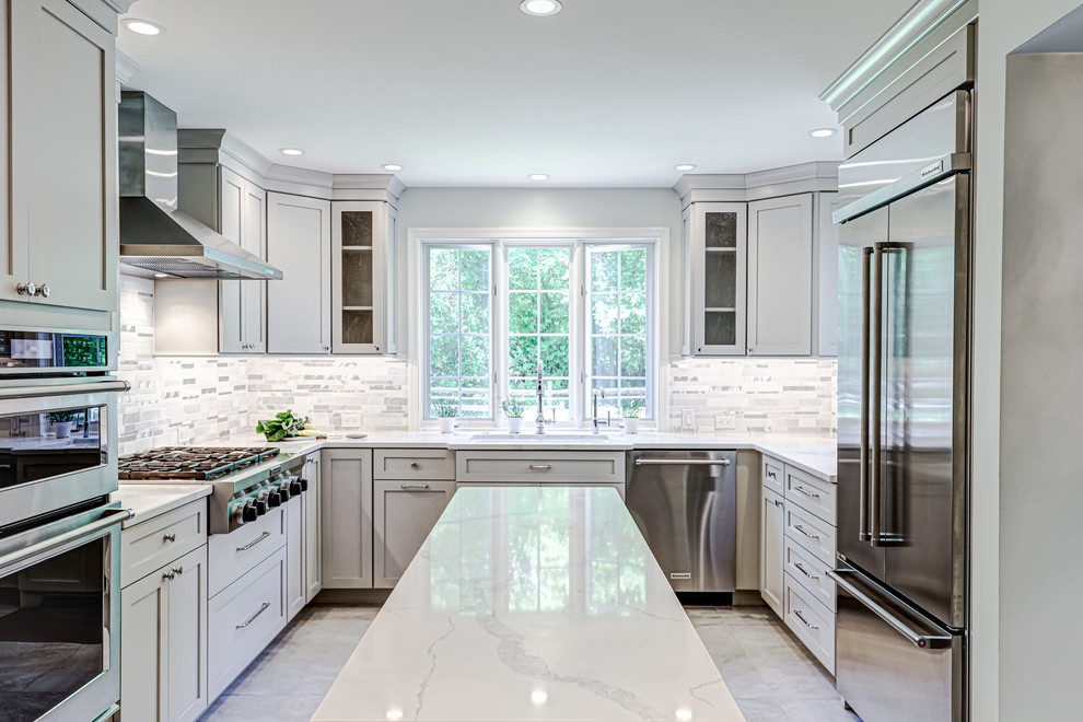 Idéer för ett mellanstort klassiskt vit kök, med en undermonterad diskho, luckor med infälld panel, grå skåp, bänkskiva i kvartsit, vitt stänkskydd, stänkskydd i stickkakel, rostfria vitvaror, klinkergolv i porslin, flera köksöar och grått golv