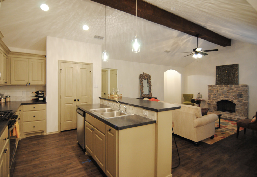Bild på ett mellanstort eklektiskt kök, med en nedsänkt diskho, luckor med infälld panel, beige skåp, laminatbänkskiva, vitt stänkskydd, stänkskydd i stenkakel, rostfria vitvaror, vinylgolv och en köksö