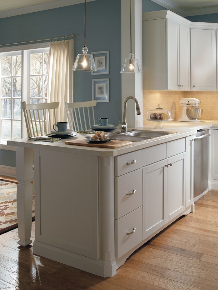 Example of an eat-in kitchen design in Other with yellow cabinets, shaker cabinets, black backsplash and stainless steel appliances