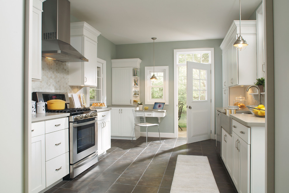 Klassische Küche mit Landhausspüle, weißen Schränken, Küchenrückwand in Beige und Küchengeräten aus Edelstahl in Sonstige