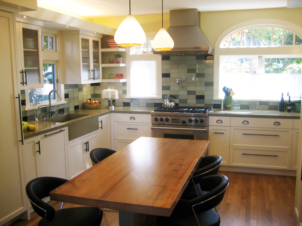 Foto på ett mellanstort funkis kök, med en enkel diskho, luckor med infälld panel, vita skåp, bänkskiva i betong, stänkskydd i glaskakel, rostfria vitvaror, mellanmörkt trägolv och flera köksöar