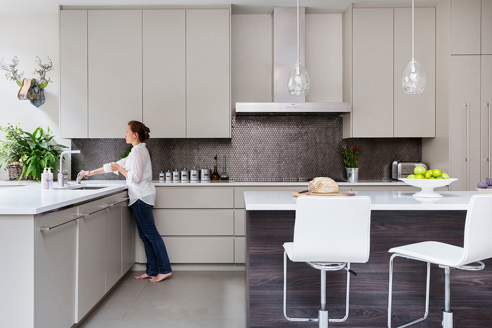 Photo of a contemporary l-shaped kitchen in London with a submerged sink, flat-panel cabinets, grey cabinets, metallic splashback, metal splashback, concrete flooring, an island and grey floors.