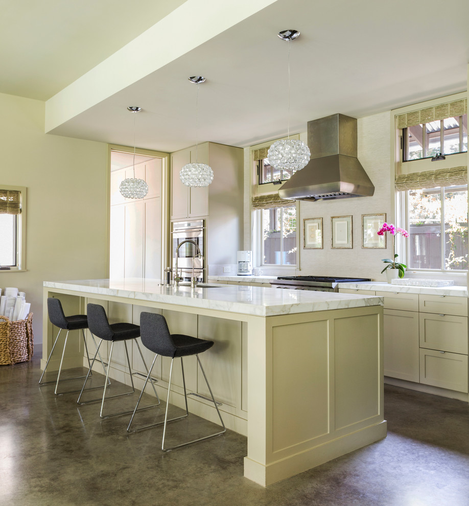 Immagine di una cucina american style di medie dimensioni con lavello sottopiano, ante in stile shaker, ante beige, top in granito, paraspruzzi beige, elettrodomestici in acciaio inossidabile e pavimento in cemento