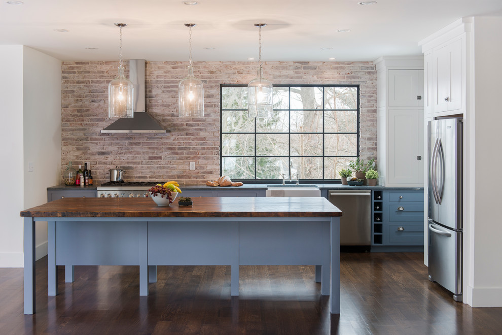 Contemporary kitchen in Boston with stainless steel appliances, wood worktops and blue cabinets.