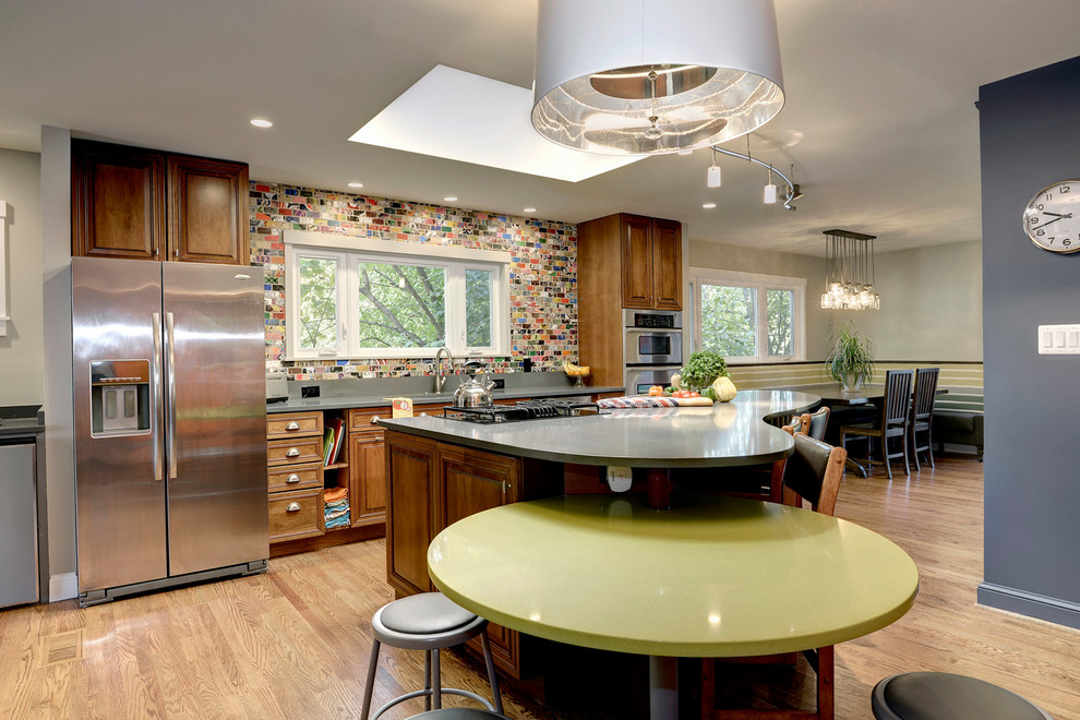Inspiration for a mid-sized contemporary single-wall medium tone wood floor eat-in kitchen remodel in DC Metro with an undermount sink, raised-panel cabinets, medium tone wood cabinets, quartz countertops, multicolored backsplash, stainless steel appliances and two islands