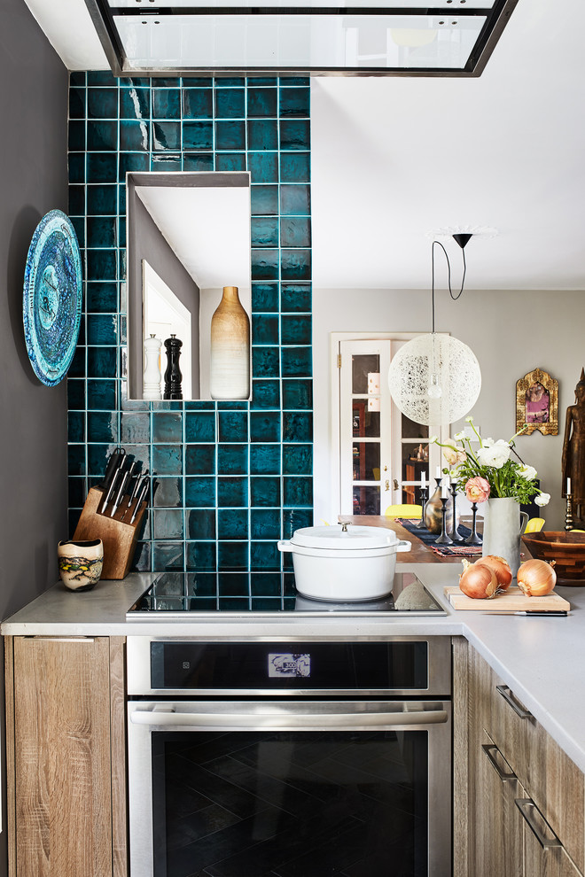 Foto de cocina industrial de tamaño medio con puertas de armario marrones, salpicadero azul, electrodomésticos de acero inoxidable, una isla y encimeras grises