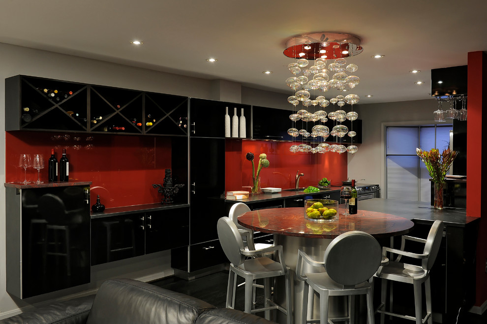 Inspiration for a medium sized contemporary single-wall kitchen/diner in DC Metro with black cabinets, red splashback, glass sheet splashback, a breakfast bar, a submerged sink, flat-panel cabinets, granite worktops, stainless steel appliances, dark hardwood flooring, grey floors and red worktops.