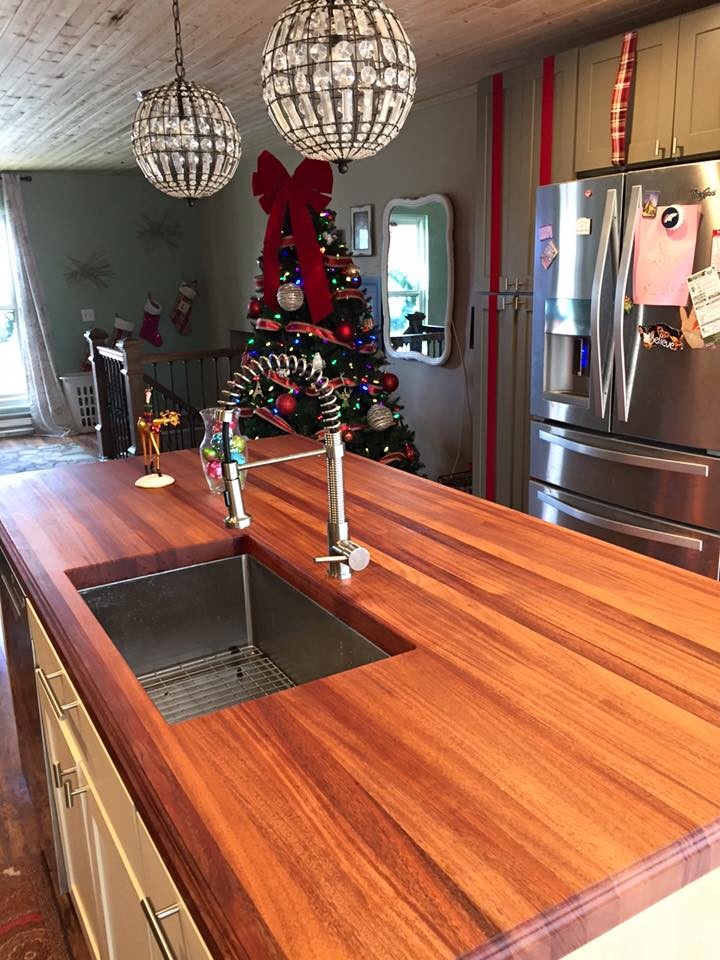 Medium sized contemporary galley kitchen/diner in Denver with a submerged sink, raised-panel cabinets, white cabinets, wood worktops, stainless steel appliances, ceramic flooring, an island, brown floors and red worktops.
