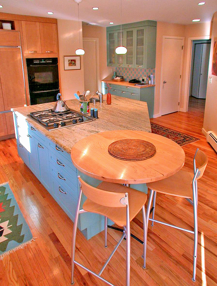 Inspiration for a mid-sized eclectic l-shaped medium tone wood floor and brown floor eat-in kitchen remodel in New York with an undermount sink, beaded inset cabinets, granite countertops, beige backsplash, ceramic backsplash, black appliances, an island, beige countertops and medium tone wood cabinets