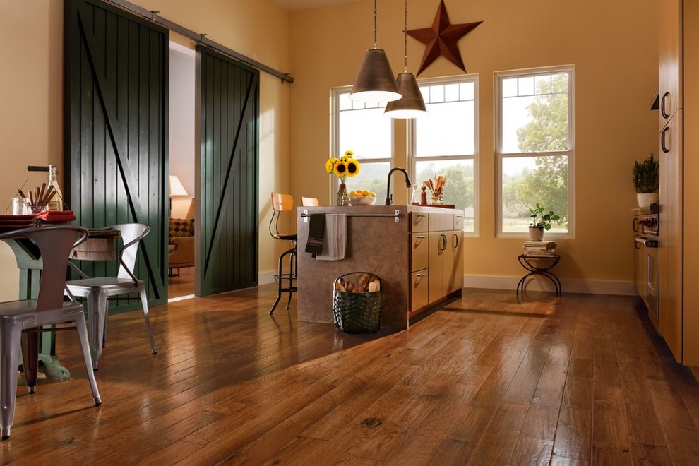 Immagine di una cucina stile rurale di medie dimensioni con ante lisce, ante in legno chiaro, elettrodomestici in acciaio inossidabile, pavimento marrone e pavimento in legno massello medio