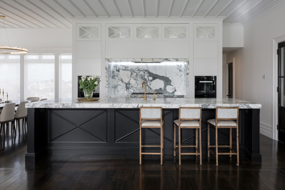 Offene, Zweizeilige Klassische Küche mit Schrankfronten mit vertiefter Füllung, weißen Schränken, Küchenrückwand in Grau, Rückwand aus Stein, dunklem Holzboden und Kücheninsel in Auckland