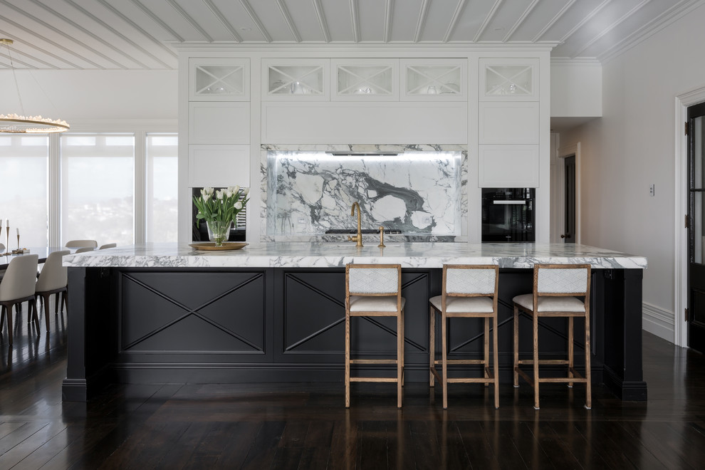 Example of a transitional galley dark wood floor open concept kitchen design in Auckland with recessed-panel cabinets, white cabinets, gray backsplash, stone slab backsplash and an island