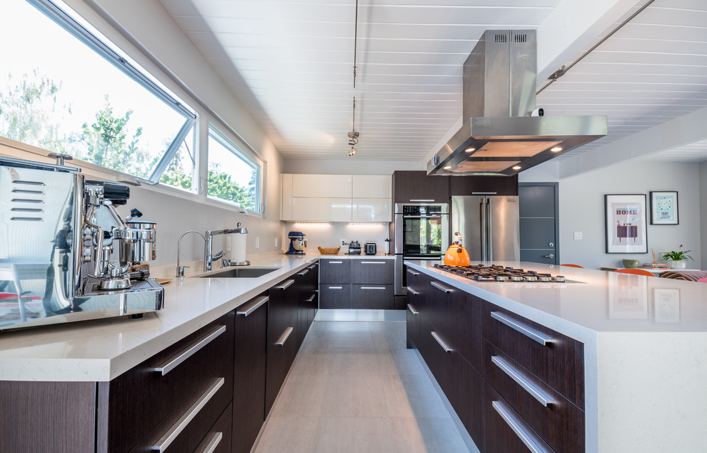 Photo of a large modern l-shaped enclosed kitchen in San Francisco with a submerged sink, flat-panel cabinets, brown cabinets, engineered stone countertops, stainless steel appliances, concrete flooring, an island and grey floors.