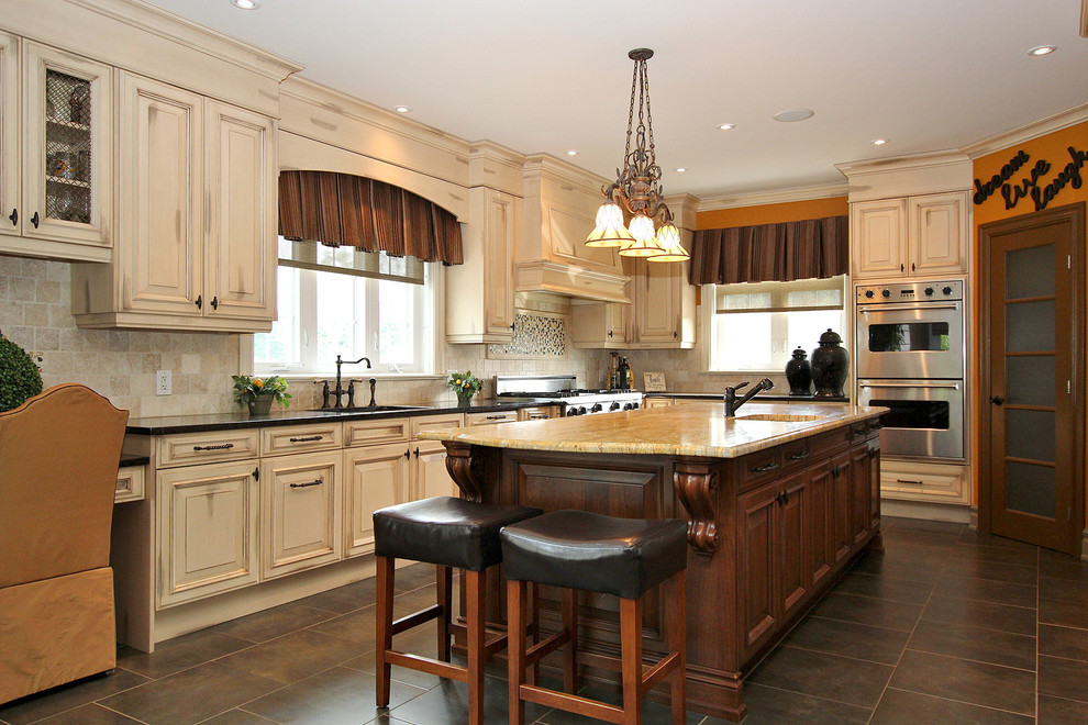 オタワにあるトラディショナルスタイルのおしゃれなL型キッチン (レイズドパネル扉のキャビネット、ベージュキッチンパネル、シルバーの調理設備、茶色い床) の写真