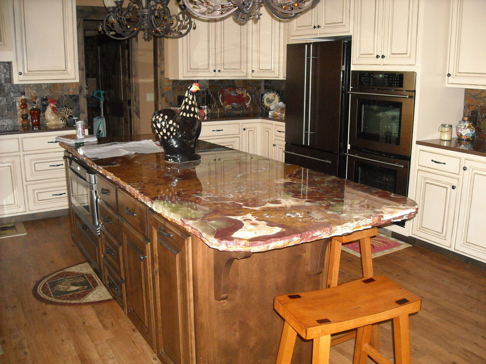 Foto på ett stort funkis kök, med en dubbel diskho, luckor med profilerade fronter, skåp i slitet trä, marmorbänkskiva, brunt stänkskydd, stänkskydd i sten, rostfria vitvaror, mellanmörkt trägolv och en köksö