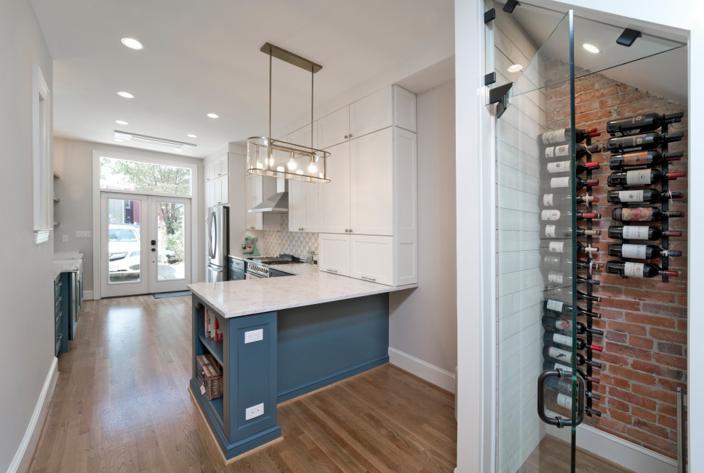 Inspiration for a small modern u-shaped medium tone wood floor eat-in kitchen remodel in DC Metro with a farmhouse sink, recessed-panel cabinets, blue cabinets, quartz countertops, white backsplash, ceramic backsplash, stainless steel appliances, a peninsula and white countertops