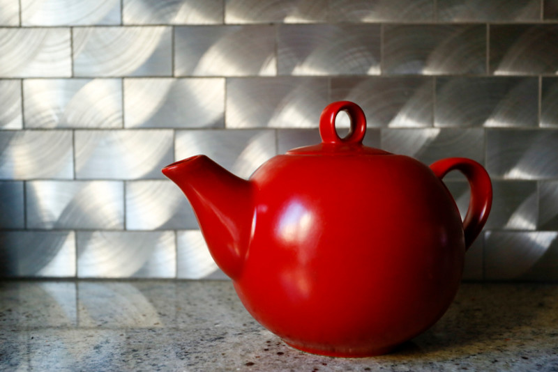 Diseño de cocina escandinava, de tamaño medio, cerrada, sin isla, con fregadero bajoencimera, armarios estilo shaker, puertas de armario de madera oscura, encimera de granito, salpicadero metalizado, salpicadero de metal, electrodomésticos de acero inoxidable y suelo de baldosas de porcelana