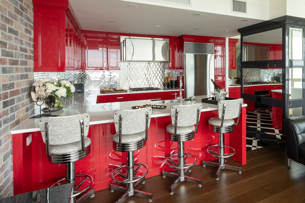 Photo of a medium sized classic u-shaped open plan kitchen in Vancouver with a belfast sink, red cabinets, engineered stone countertops, metallic splashback, stainless steel appliances, a breakfast bar, multi-coloured floors, white worktops, recessed-panel cabinets and metal splashback.