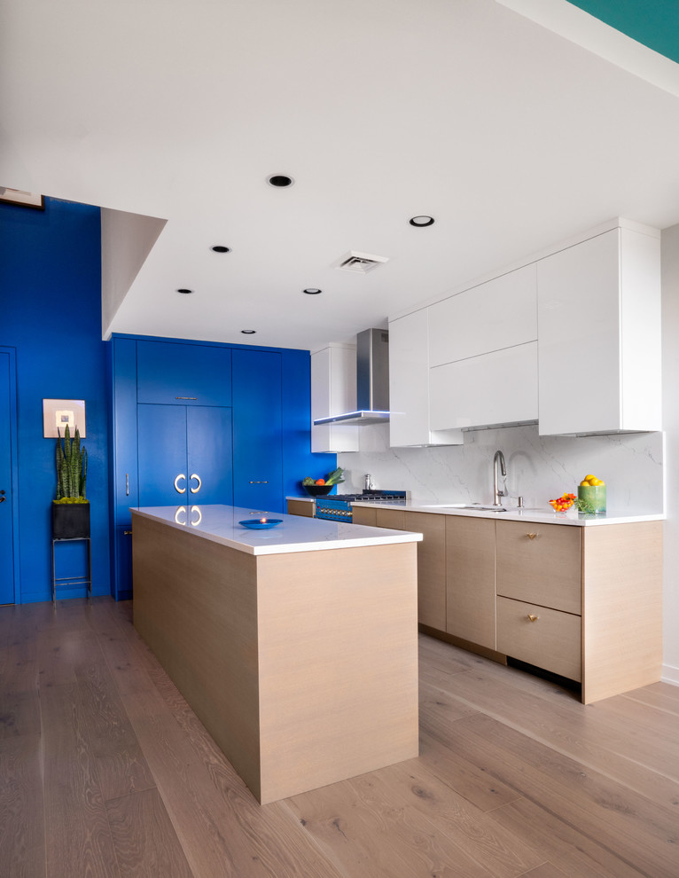 Immagine di una cucina contemporanea di medie dimensioni con lavello integrato, ante lisce, ante blu, top in marmo, paraspruzzi bianco, paraspruzzi in marmo, elettrodomestici da incasso, parquet chiaro e top bianco