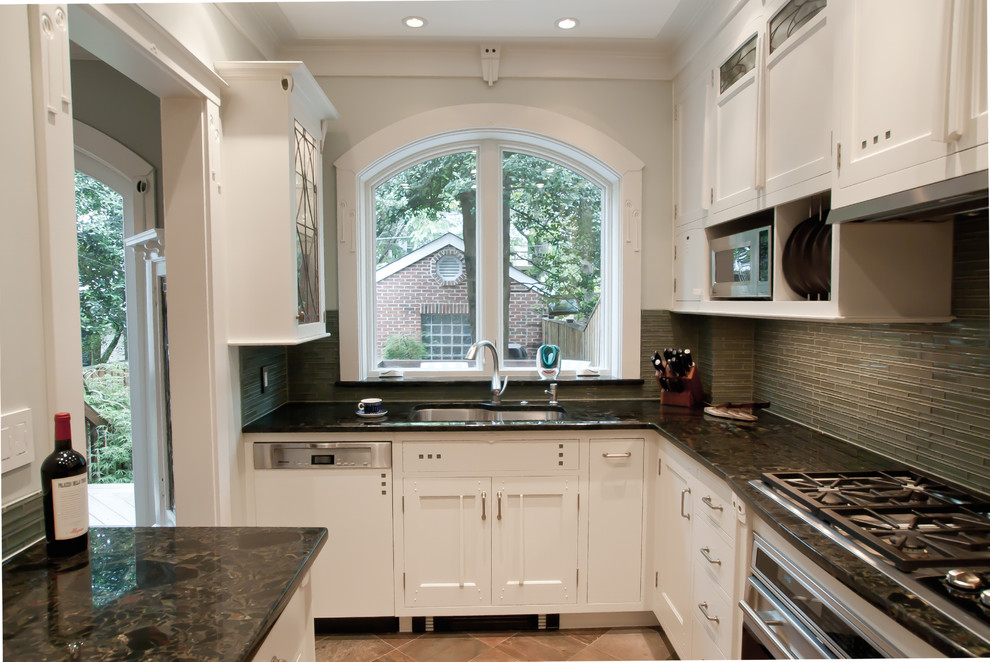 Inspiration for a small traditional u-shaped kitchen pantry in DC Metro with a submerged sink, flat-panel cabinets, white cabinets, granite worktops, green splashback, glass tiled splashback, integrated appliances and slate flooring.