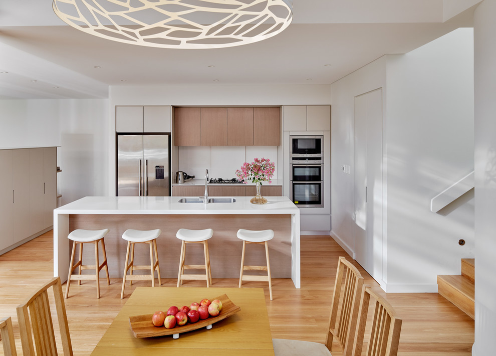 Design ideas for a medium sized contemporary single-wall kitchen/diner in Sydney with a double-bowl sink, ceramic splashback, stainless steel appliances, medium hardwood flooring, an island and light wood cabinets.