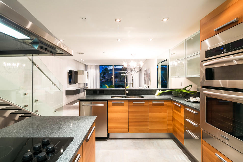 This is an example of a modern l-shaped kitchen pantry in Miami with a double-bowl sink, medium wood cabinets, granite worktops, white splashback, stainless steel appliances, porcelain flooring and multiple islands.