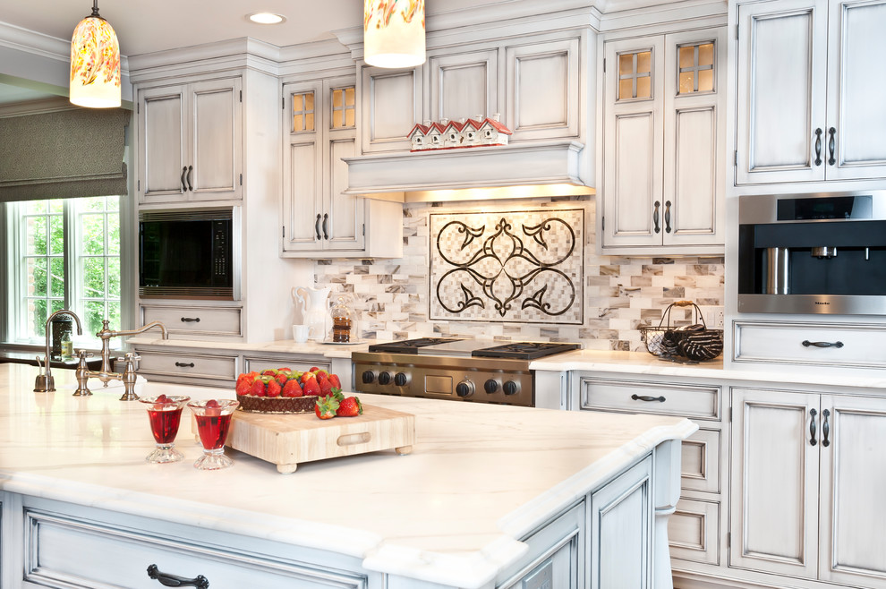 Klassisk inredning av ett stort vit linjärt vitt kök och matrum, med en rustik diskho, luckor med profilerade fronter, vita skåp, flerfärgad stänkskydd, stänkskydd i keramik, rostfria vitvaror, ljust trägolv, en köksö och brunt golv