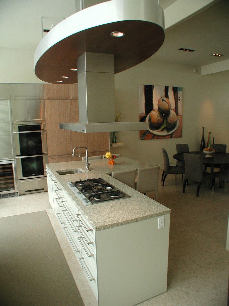 Exempel på ett mellanstort modernt kök, med en undermonterad diskho, släta luckor, beige skåp, bänkskiva i terrazo, rostfria vitvaror, korkgolv och en köksö
