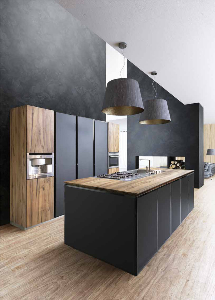 Design ideas for a medium sized contemporary galley open plan kitchen in London with an integrated sink, flat-panel cabinets, light wood cabinets, wood worktops, integrated appliances and an island.
