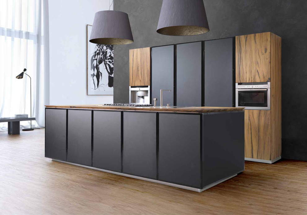 Immagine di una cucina design di medie dimensioni con lavello integrato, ante lisce, ante in legno chiaro, top in legno e elettrodomestici da incasso