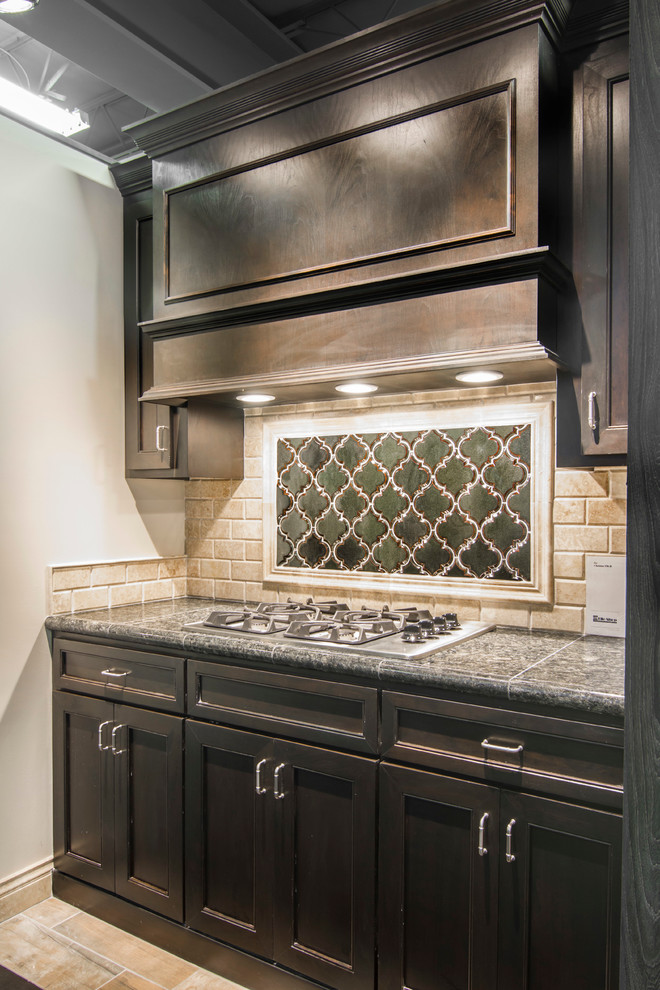 Cette image montre une cuisine chalet en bois foncé avec un placard à porte shaker, un plan de travail en granite et une crédence beige.