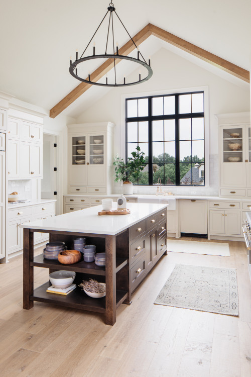 Dark Wood Central Island with Circular Chandelier in a Farmhouse Kitchen Cabinets with White Countertop