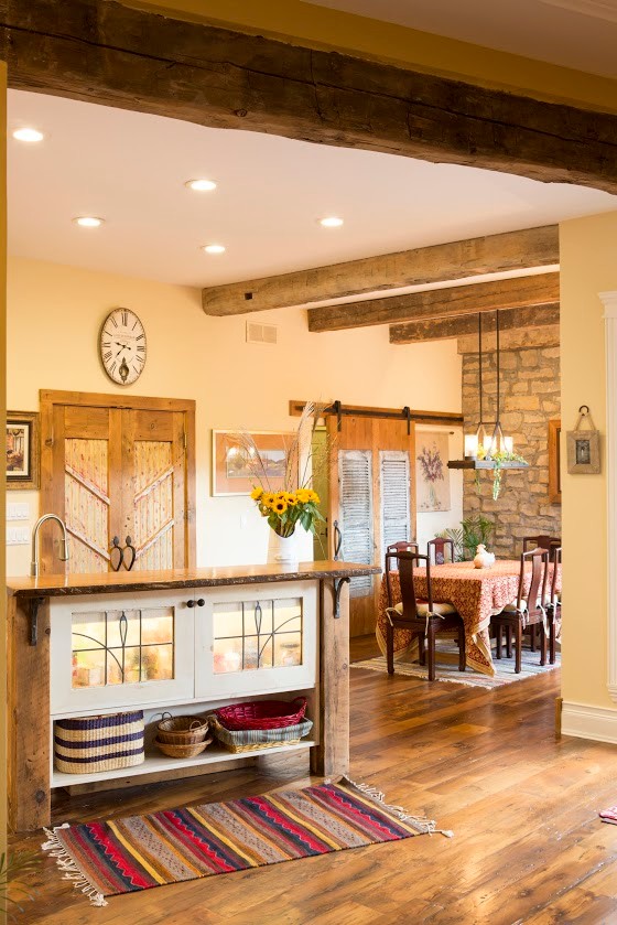 Bild på ett mellanstort amerikanskt u-kök, med en rustik diskho, luckor med infälld panel, beige skåp, bänkskiva i koppar, beige stänkskydd, rostfria vitvaror, mörkt trägolv och flera köksöar