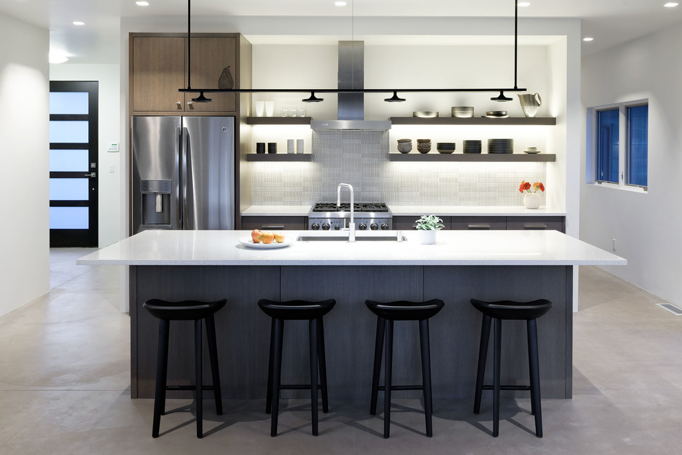 Inspiration for a medium sized contemporary galley kitchen in Denver with a submerged sink, flat-panel cabinets, brown cabinets, glass tiled splashback, stainless steel appliances, concrete flooring, an island and grey floors.