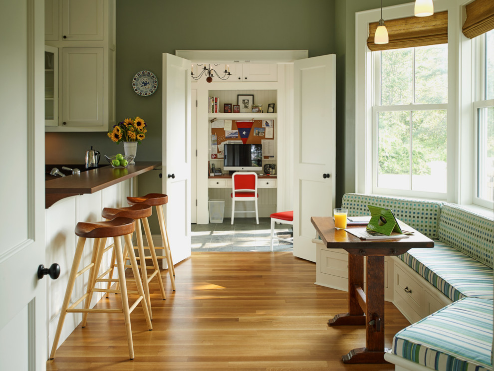 Foto de cocina costera con armarios con paneles empotrados, puertas de armario blancas, encimera de madera, suelo de madera clara y una isla