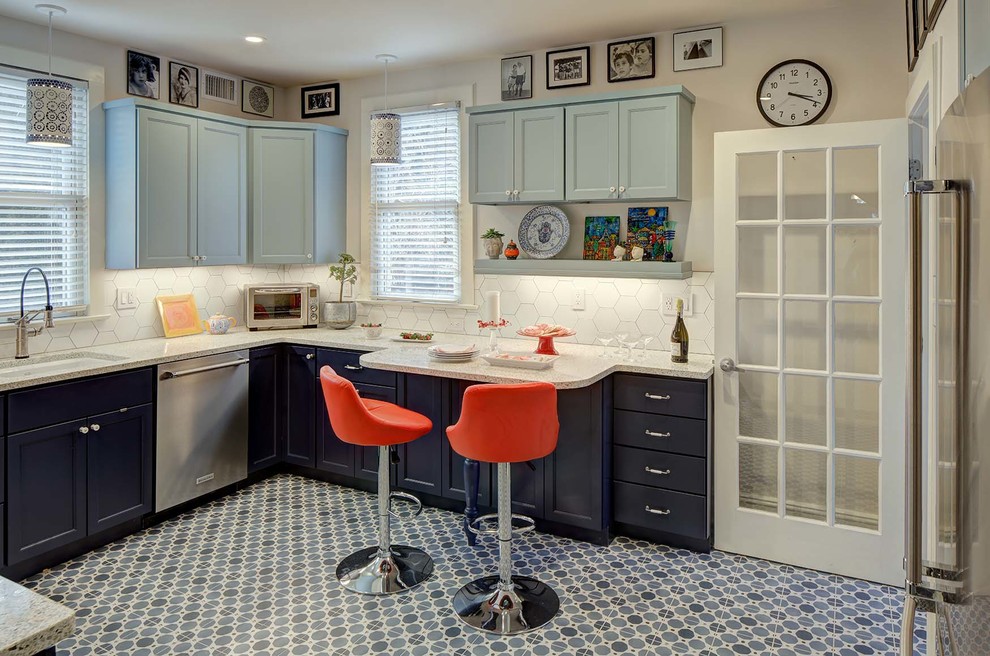 Inredning av ett eklektiskt mellanstort flerfärgad flerfärgat u-kök, med en enkel diskho, skåp i shakerstil, blå skåp, bänkskiva i kvarts, vitt stänkskydd, stänkskydd i keramik, rostfria vitvaror, klinkergolv i porslin, en halv köksö och blått golv