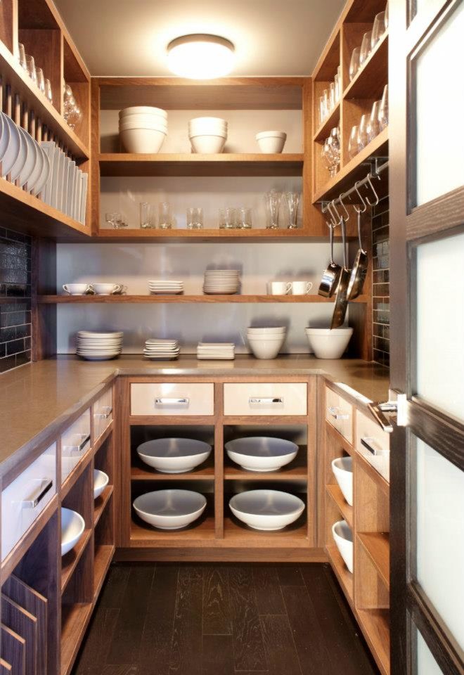 Mittelgroße Küche mit Vorratsschrank, hellen Holzschränken, Küchenrückwand in Weiß, schwarzen Elektrogeräten und dunklem Holzboden in New York