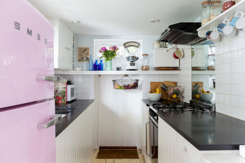 Zweizeilige Shabby-Chic Küche ohne Insel mit Unterbauwaschbecken, weißen Schränken, Küchenrückwand in Weiß und bunten Elektrogeräten in London