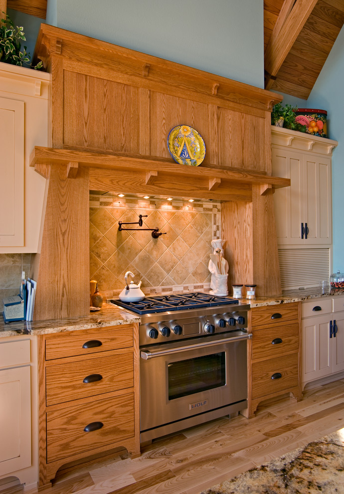 Exemple d'une cuisine ouverte craftsman en U et bois clair avec un évier encastré, un placard à porte shaker et un électroménager en acier inoxydable.