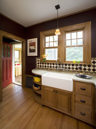 Example of a small arts and crafts u-shaped medium tone wood floor enclosed kitchen design in New York with a farmhouse sink, beaded inset cabinets, medium tone wood cabinets, granite countertops, multicolored backsplash, ceramic backsplash, stainless steel appliances and a peninsula
