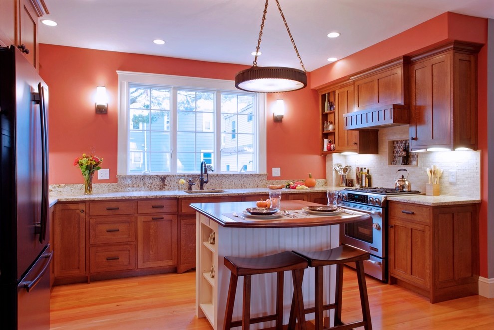 ボストンにあるトラディショナルスタイルのおしゃれなキッチン (シングルシンク、中間色木目調キャビネット、ベージュキッチンパネル、シルバーの調理設備、シェーカースタイル扉のキャビネット) の写真