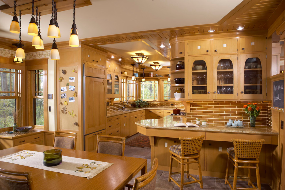 Example of an arts and crafts u-shaped slate floor eat-in kitchen design in Minneapolis with an undermount sink, flat-panel cabinets, light wood cabinets, brown backsplash, paneled appliances and a peninsula
