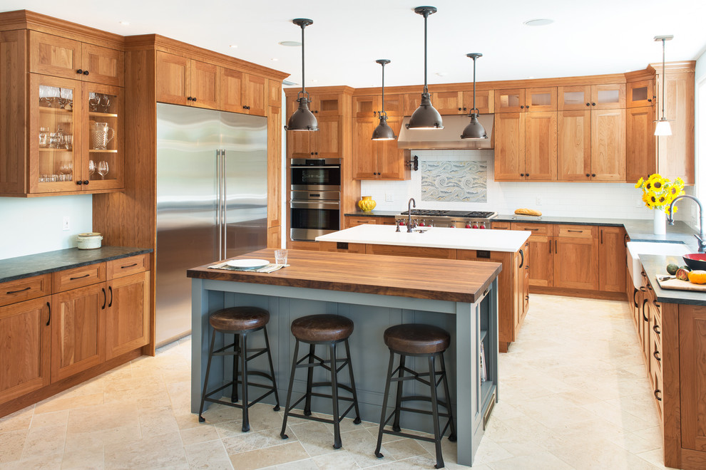 Inspiration for a timeless beige floor kitchen remodel in Boston with a farmhouse sink, shaker cabinets, medium tone wood cabinets, multicolored backsplash, stainless steel appliances, two islands and white countertops
