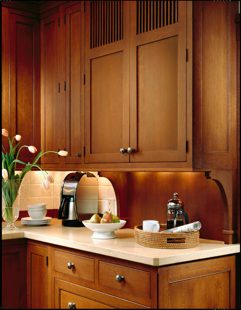 Inspiration for a large timeless l-shaped light wood floor enclosed kitchen remodel in Chicago with a single-bowl sink, flat-panel cabinets, dark wood cabinets, limestone countertops, beige backsplash, ceramic backsplash, paneled appliances and an island